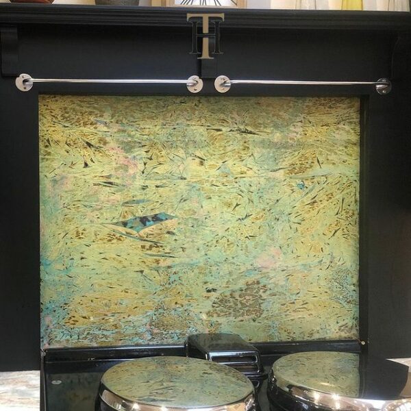 decorative brass splashback with blues greens and pinks