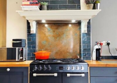 aged copper kitchen splashback behind stove