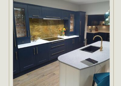 patterned aged brass splashback in blue kitchen