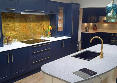 aged brass splashback in blue kitchen