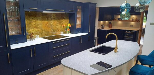 aged brass splashback in blue kitchen