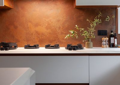 aged copper splashback in modern white kitchen