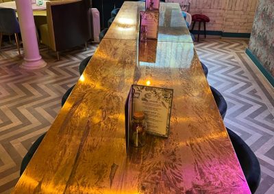 aged brass table tops in modern warehouse style restaurant