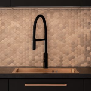 Modern black kitchen worktop and sink with copper tiles on the wall