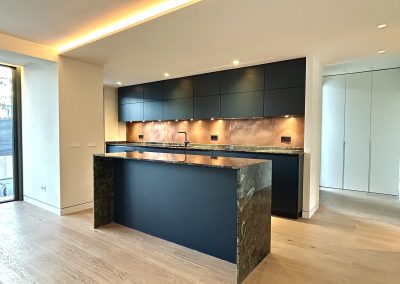 aged copper backsplash against dark kitchen cupboards